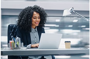 Black-Businesswoman-Sitting-at-Her-Desk-Working-on-a-Laptop-Computer-for-must-read.