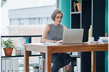Business,-mature-woman-and-laptop-in-office-for-financial-planning,-company-payroll-or-bookkeeping-for-must-read.